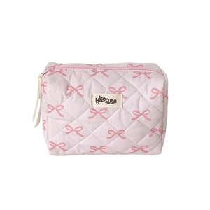Pink quilted makeup bag with ribbon bow patterns and a rectangular travel design