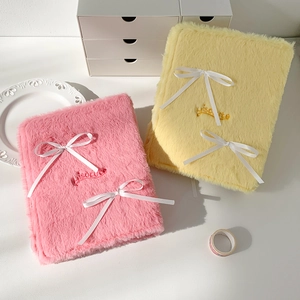 Close-up of soft plush photo album cover with ribbon bows and Jisocute embroidery