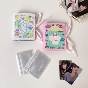 Close-up of mini loose-leaf photo albums with pink ribbons and transparent inner sleeves