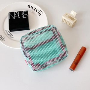 Close-up of a light green mesh cosmetic bag with hisocute label and soft pink lining