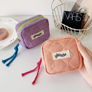 Close-up of quilted checkered mini makeup bags in purple and orange with colorful zippers