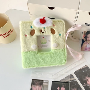 Detail of plush animal photo album with dog embroidery and cherry charm for card storage