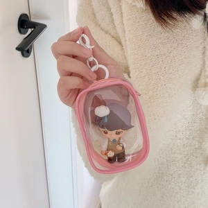 Detail of clear pink PVC doll display case with white hook and miniature figure