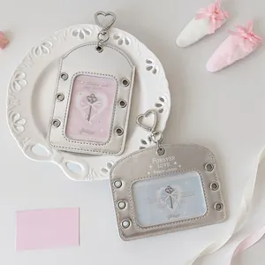 Detail of silver ribbon card holder with metal eyelets and heart-shaped keychain