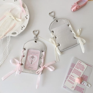 Detail of silver PU leather card holder with heart hook and delicate ribbon bow decoration