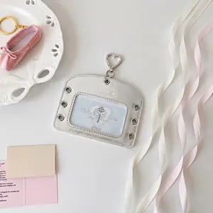 Silver ballet-style card holder with heart buckle and metallic eyelets on white surface