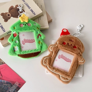 Close-up of plush Christmas tree and gingerbread man card holders with metal hooks