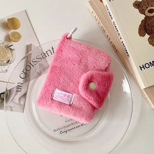 Detailed view of pink plush coin purse featuring a soft texture and a button closure