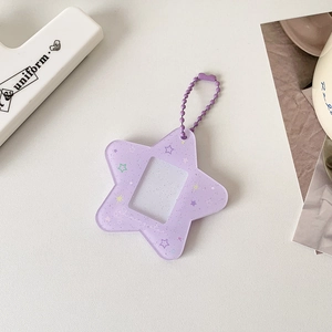 Dettaglio di portafoto a stella in acrilico viola glitterato con catena a sfere
