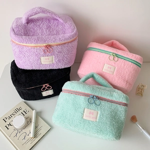Close-up of fluffy pastel makeup bags in purple, pink and mint with soft plush texture