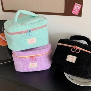 Plush makeup bags in mint green, violet, and black with dual zippers and sturdy handles