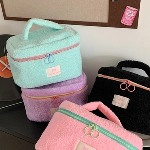 Detail showing plush candy-colored makeup bags with top handles and dual metal zippers