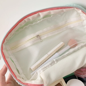 Detail of mint green makeup bag interior showing mesh pocket and large capacity storage