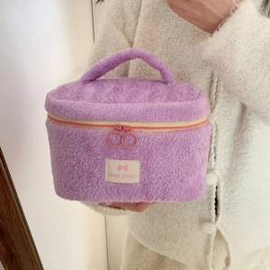 Detail of purple plush vanity bag with dual-colored zipper and Lucky Sale woven label