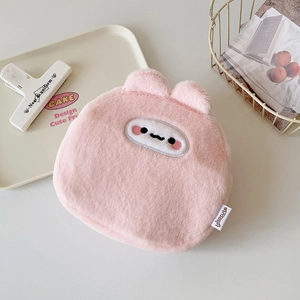Close-up of pink plush cartoon animal makeup bag with soft texture and brand label