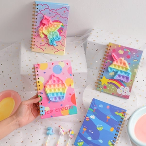 Detail of spiral notebook with unicorn pop-it fidget toy cover and matching pens