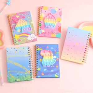 Flat lay of pop-it fidget notebooks featuring unicorn and dinosaur silicone covers