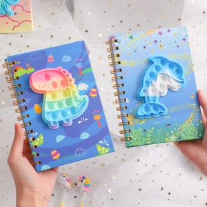 Detail view of Pop It silicone notebook covers with dinosaur and dolphin patterns for kids