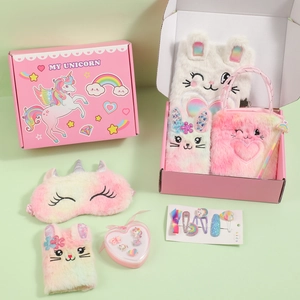 Detail of pink unicorn plush gift set including notebook, eye mask, and fluffy handbag