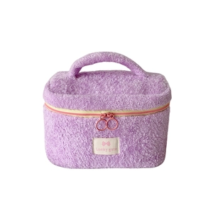 Cute lilac fuzzy makeup bag with Lucky gate label and pink zipper on white background
