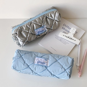 Detailed close-up of quilted candy color pencil cases with soft padding and woven label