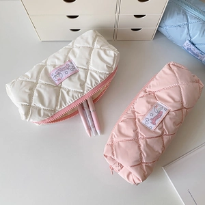 Detailed view of quilted pastel pouches showing fluffy texture and secure zippers
