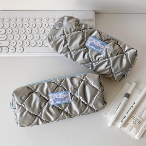 Detail of silver quilted stationery pouches with blue cartoon patch and light blue zippers