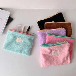 Minimalist soft plush makeup bags in multiple colors with zipper and woven label