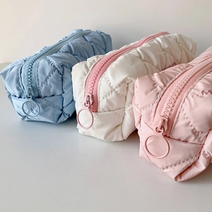 Close-up of quilted candy color pencil cases with cloud texture and round zipper pulls