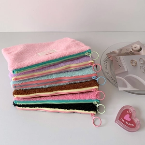 Group shot of colorful plush pouches featuring fuzzy texture and large ring zippers