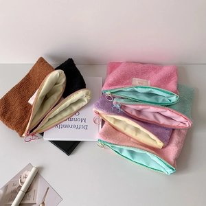 Detail of plush envelope makeup bags in various colors with soft fleece texture