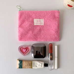 Pink plush teddy fleece cosmetic bag with green zipper ring and makeup accessories