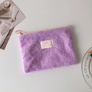 Detail of purple plush storage pouch with soft microfiber texture and pink zipper closure