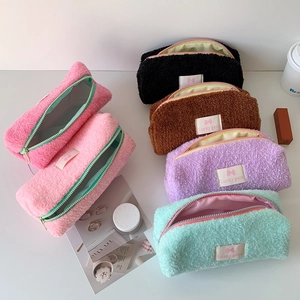 Close-up of plush faux fur stationery pouches in multiple colors with Lucky gate labels