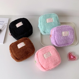 Cinq pochettes carrées en peluche de couleurs variées avec étiquettes Lucky Gate et zip