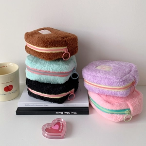 Gros plan de trousses à maquillage en peluche avec fermetures éclair et anneaux en métal