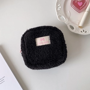 Détail du petit sac peluche noir avec broderie nœud rose et fermeture à glissière latérale