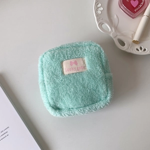 Détail de la pochette carrée en peluche vert menthe avec étiquette Lucky gate douce