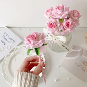 Bolígrafo de rosa rosa con flor de seda decorativa y hojas verdes para regalo creativo