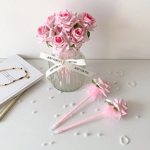 Primer plano de bolígrafos de rosa rosa con plumas y cinta de raso en un jarrón de cristal