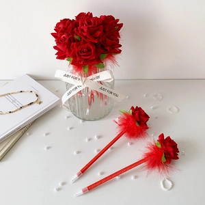 Detalle de bolígrafos de pluma rosa roja en jarrón de vidrio con perlas decorativas