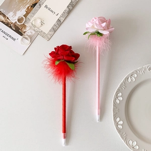 Detalle de bolígrafos de pluma con rosas artificiales rojas y rosas en fondo blanco estético
