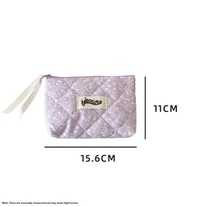 Detail view of purple quilted storage bag with dimensions 11cm by 15.6cm and brand label