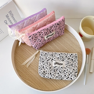 Detailed view of four assorted floral and splattered ink quilted cotton cosmetic bags
