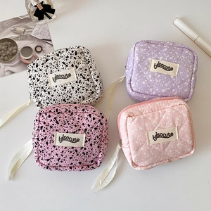 Quilted square storage bags with ink splatter patterns for lipstick and earphones