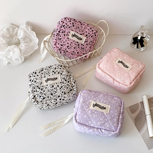 Detail of four colorful quilted makeup bags with ribbon zippers and polka dot patterns
