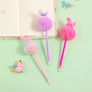 Close-up of cute unicorn pens with fluffy pom-poms and glitter sequins on a notebook