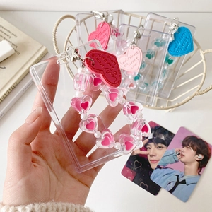 Close-up of clear acrylic photo card holder with heart beads and leather tag