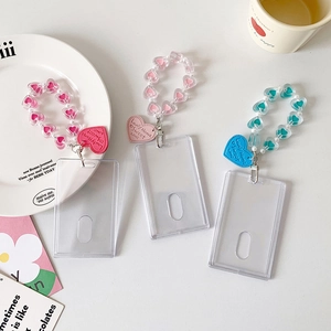 Detailed view of three acrylic photocard holders with colorful heart bead lanyards