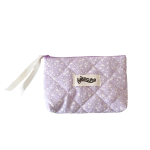 Purple quilted makeup bag with ink splatter pattern and Hisocute brand woven label